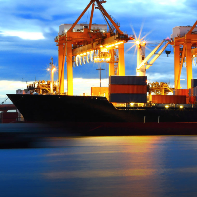 a large cargo ship in a harbor at dusk